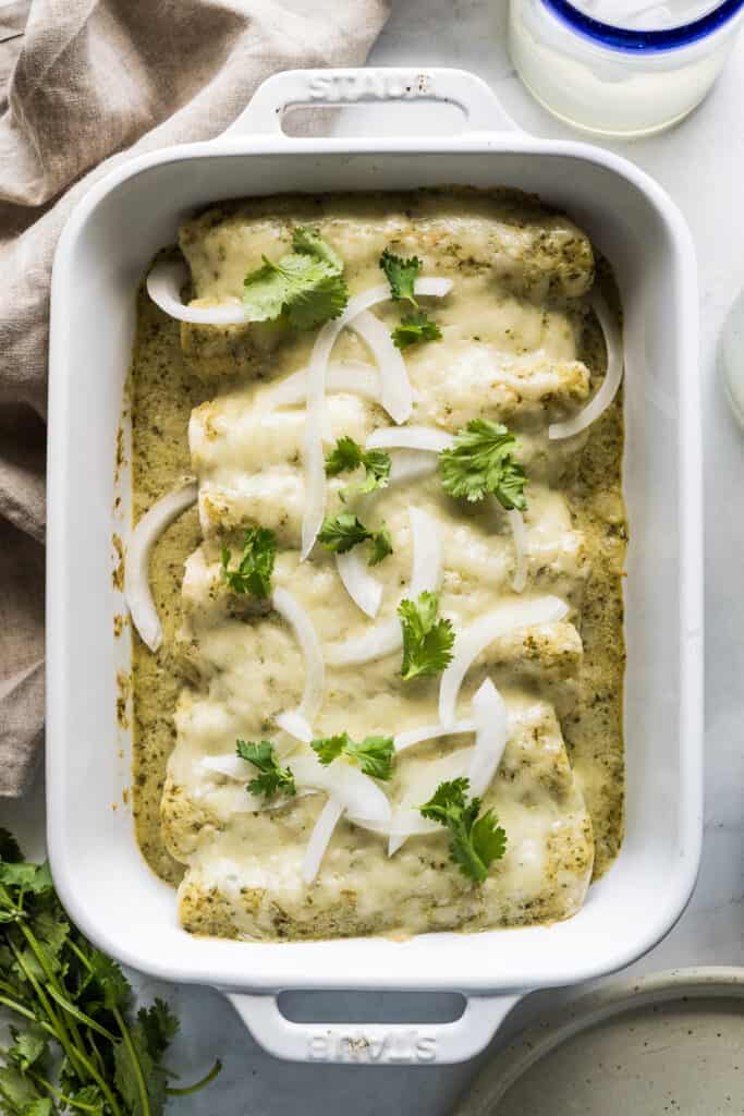 The ingredients for enchiladas suizas include corn tortillas filled with chicken, a creamy green sauce, and loads of cheese!

